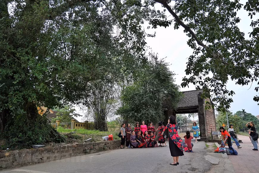 Visitors pose for a photo in front of the gate of Duong Lam village in Son Tay town, Hanoi. The gate welcomes visitors to a journey promising them an insight into a typical countryside life in the north of Vietnam. Here, both tangible and intangible cultural values intertwine to give the village the speciality that can be found nowhere else. Located more than 40 kilometres to the northwest of the capital city’s centre, Duong Lam is one of the best examples of an ancient village in Vietnam. In 2005, it became the first village recognised as a national architectural - artistic relic site. (Photo: VietnamPlus)