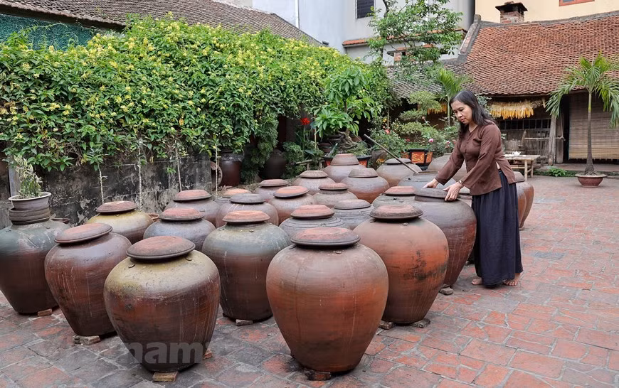 Each jar contains up to hundreds of litres of soya sauce, which is an indispensable souvenir once visitors come to Duong Lam. The longer the sauce is kept, the more delicious it will be. Visiting ancient houses in Duong Lam, visitors can buy this salty paste made from fermented soybean as gift. Earthenware jars containing ‘tuong’ line the yards, gently oozing a signature savory and nutty scent. ‘Tuong’ is a popular dipping sauce in northern Vietnam's countryside and also used as a condiment for cooking. Traditional cultural values, a landscape and architecture typical for the Red River Delta’s countryside, and various delicacies have made Duong Lam village an ideal tourist destination. (Photo: VietnamPlus)