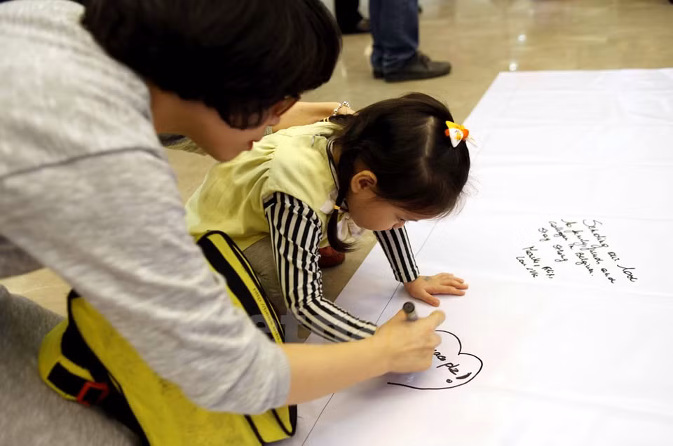 Participants write down words in commemoration of the victims (Photo: VNA)
