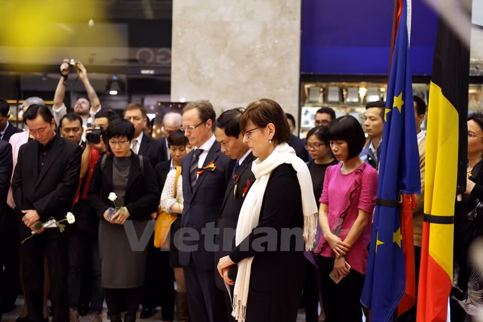The participants hold a one-minute silence in memory of the victims of the Brussels attacks (Photo: VNA)