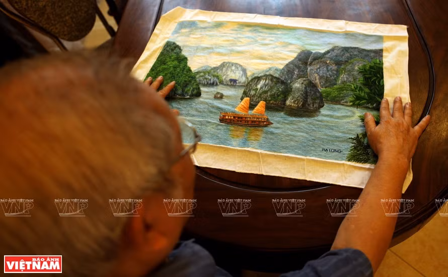 Artisan of Quat Dong embroidery artisan introduces Ha Long Bay's natural landscape painting to international friends (Photo: VNA)