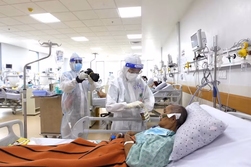 A VNA reporter covers COVID-19 treatment at a hospital (Photo: VNA)