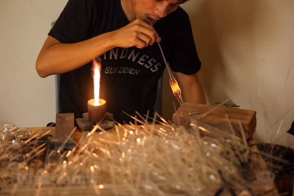 Since the 1960s, glass blowing has been the main source of income for most of the local people in Thong Nhat commune. At that time, villagers produced simple items such as Philatop syringe, bulb, bottle and jar, among others. Increasing demands from customers far and wide have forced villagers to find a way to improve their productivity. Luong Van Trai, a local resident who own a test tube production facility, said his family spent around 8,500 USD on buying a machine to help increase productivity. The machine can replace the workload of 10 to 15 workers, so the job is much easier. The initial state, however, still involves manual work to create raw glass tubes. (Photo: VietnamPlus)