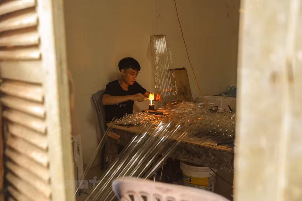 From basic tools, residents in Thong Nhat commune, Thuong Tin district, the capital city of Hanoi could produce simple and useful glassware like light bulbs, bottles, vases, vacuum flask stoppers or any other delicate products according to customers’ demands. Since the 1960s, glass blowing has been the main source of income for most of the local people in Thong Nhat commune. Among villages in the commune, Giap Long and Hoang Xa villages are the most developed areas with a large number of skilled workers who can produce complicated and delicate glassware. According to Le Xuan Tien, who has more than 20 years of experience in glassware making in Thong Nhat commune, almost all villagers engaged in the job ten years ago. (Photo: VietnamPlus)