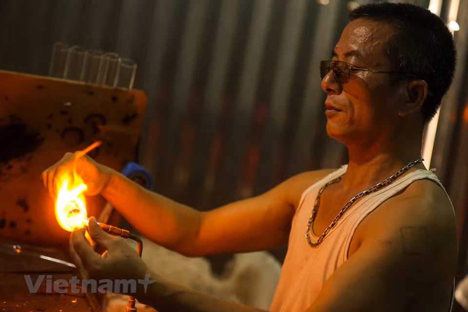 The glass-blowing technique plays a crucial role in creating products. A glass-blower has to hold his breath properly to produce specific products. A skillful glass-blower needs to know the ‘ripeness’ of glass. As glass is initially exposed to fire, it will appear blue in color before turning white. At that time, a slight blow is enough to mold the blob of molten glass into products of their desired shape. Although sales were slowing due to COVID-19, local villagers have to keep up the job to ensure livelihoods. Since the 1960s, glass blowing has been the main source of income for most of the local people in Thong Nhat commune. (Photo: VietnamPlus)