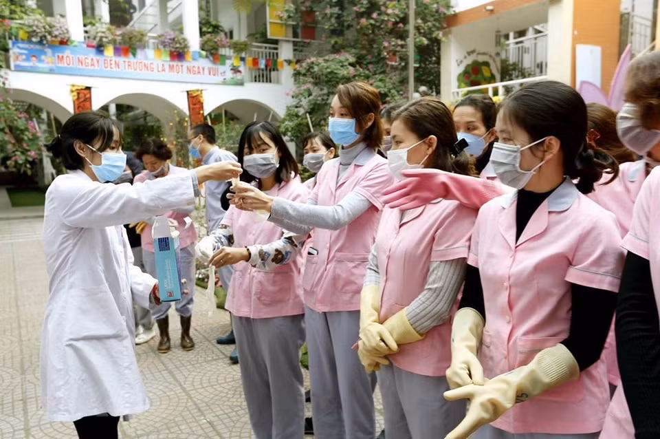 A health staff guides teachers in Hai Ba Trung District (Hanoi) through environmental sanitation to prevent acute respiratory disease caused by nCoV (Photo: VNA)