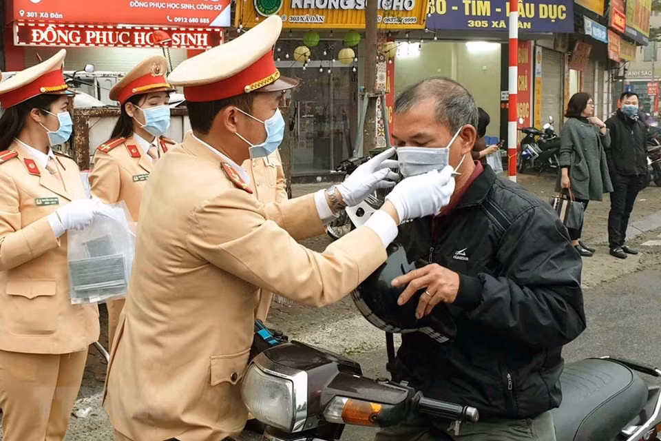 Hanoi Traffic Police give free masks to people in traffic (Photo: VNA)