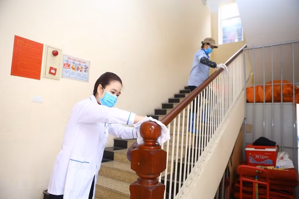 Staff disinfect stair handrails’ surface at Tran Nhan Tong High School (Hanoi) (Photo: VNA)