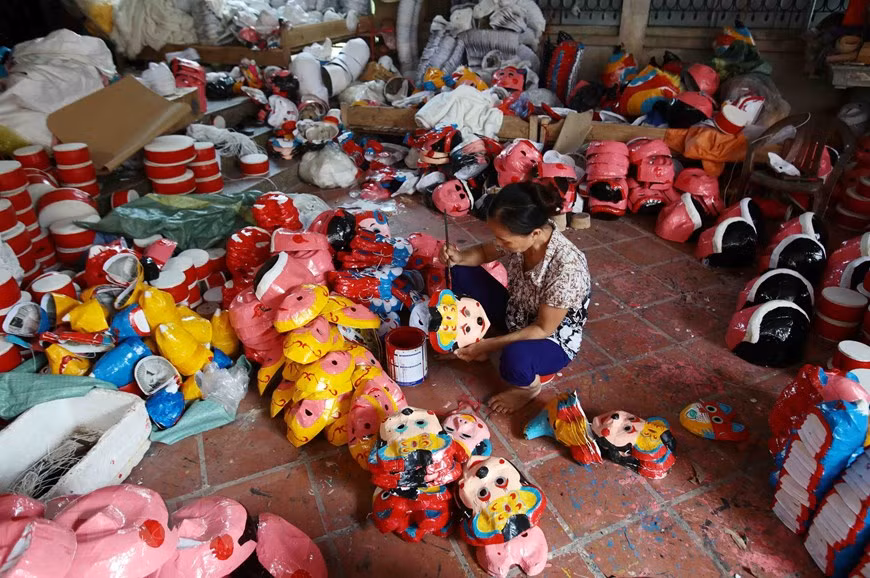 The places that can catch the sun, the large yard in front of the house, the wall or the road in the village are packed with logs for making drums or paper masks. (Photo: VNA)