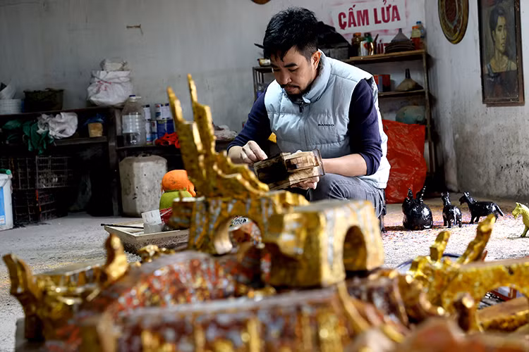 Through Phat’s great skill, a piece of wood undergoes many processing steps to become a sophisticated sculpture, from carving to dyeing and gold inlaying. (Photo: VNA)