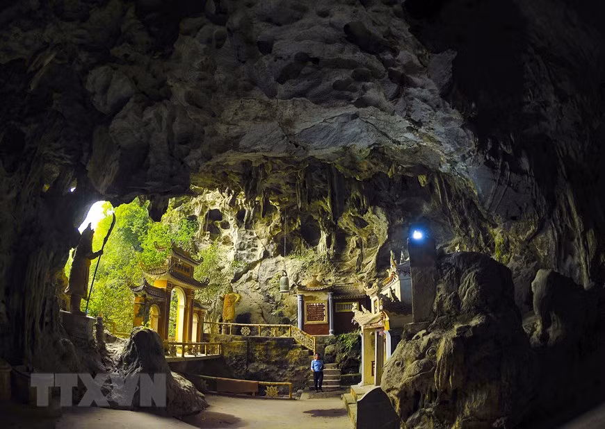 Entrance to Light cave impresses visitors with a nearly one-tonne bell from the Nguyen Dynasty hung at its eight-metre natural dome and two giant statues of Guardians (Photo: VNA)