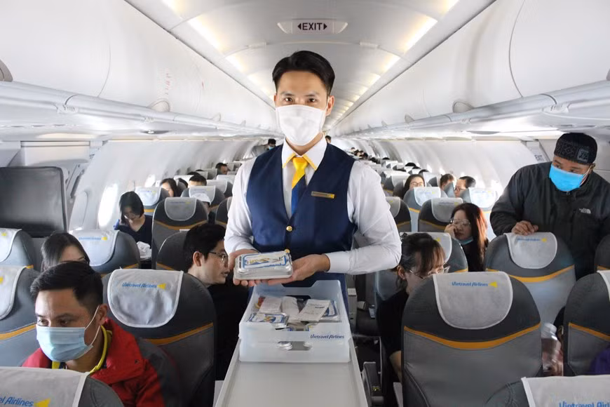 Flight attendants serve meals for passengers on the flight (Photo: Vietnam+)