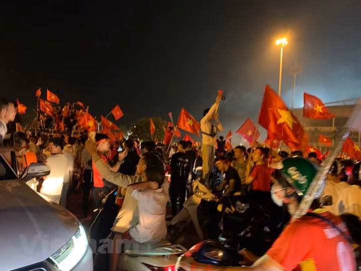  Streets are jam-packed with delirious fans waving the Vietnamese flag. (Photo: VNA)