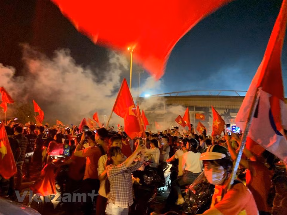  Streets are jam-packed with delirious fans waving the Vietnamese flag. (Photo: VNA)