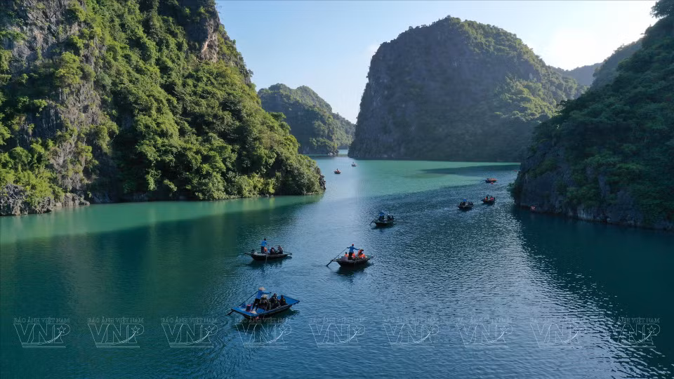 Tourists take a boat on Lan Ha Bay to explore the Light Cave and the Dark Cave. (Photo: VNP/VNA)