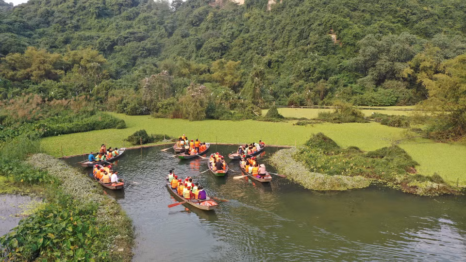 Tourists take a boat to Thung Nang (Sunshine Valley). Thung Nang is a low-lying place, flooded and surrounded by majestic high mountains, separated from the noisy life rhythm. (Photo: VNA)