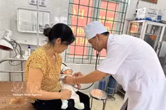 A doctor at Trung Nguyen Medical Station in Te Lo commune, Phu Tho province, examines a child patient. (Photo: VNA)