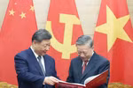 Party General Secretary To Lam (right) presents Party General Secretary and President of China Xi Jinping a photo book by the Vietnam News Agency featuring typical and impressive photos of Xi's five visits to Vietnam since 2011 (Photo: VNA)