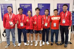 Teqball players Trinh Gia Nghi (third from left), Nguyen Hoang Minh Tan (fourth from left) and their coaches pose for a photo after winning a bronze medal at the 20th ASIAD. (Photo published by VNA)
