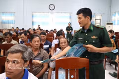 A border guard of Dak Lak distributes leaflets on anti-IUU fishing regulations to fishermen at the conference on October 15, 2026. (Photo: VNA)