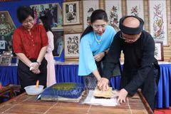 Visitors to Bac Ninh try making a Dong Ho folk painting. (Photo: VNA) 
