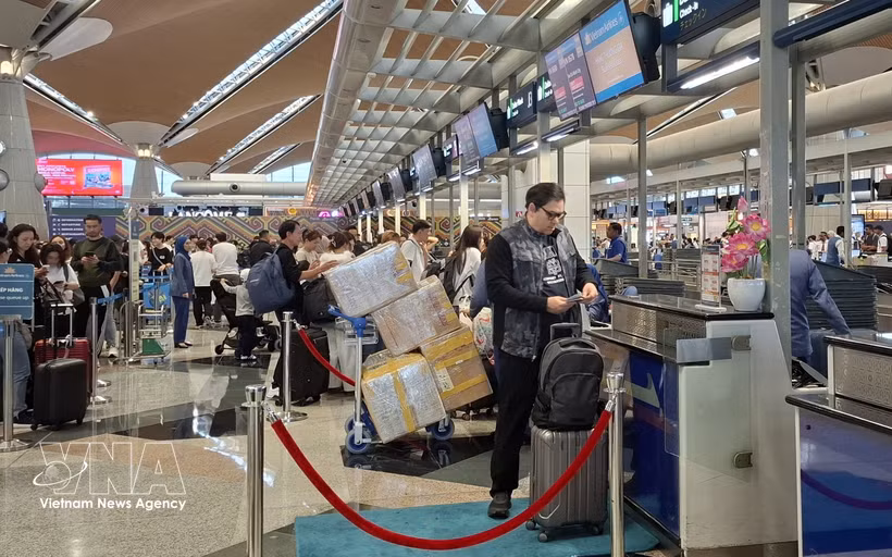 Passengers handle boarding procedures at Kuala Lumpur International Airport of Malaysia. (Photo: VNA)