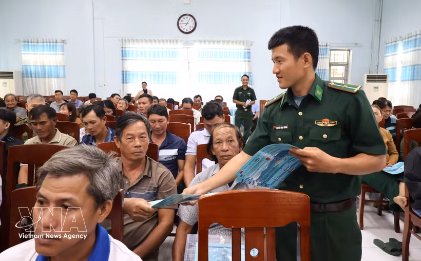 A border guard of Dak Lak distributes leaflets on anti-IUU fishing regulations to fishermen at the conference on October 15, 2026. (Photo: VNA)