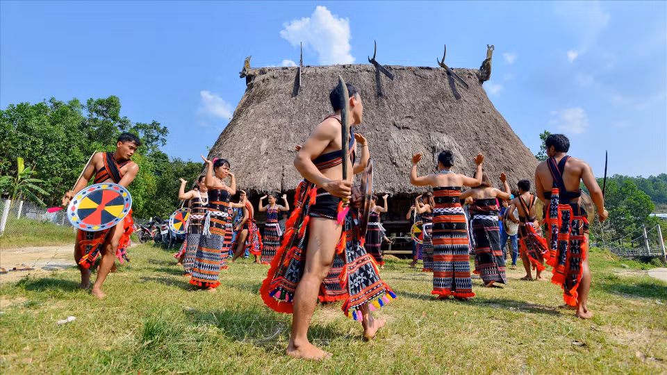 Co Tu men and women perform a traditional dance in front of the house. (Photo: Vietnam Pictorial)