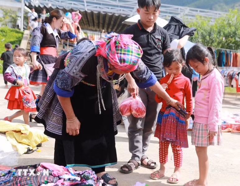 The market day isn’t just for adults. It is also a joy for children with the excitement of their mothers buying them new clothes. (Photo: VNA)