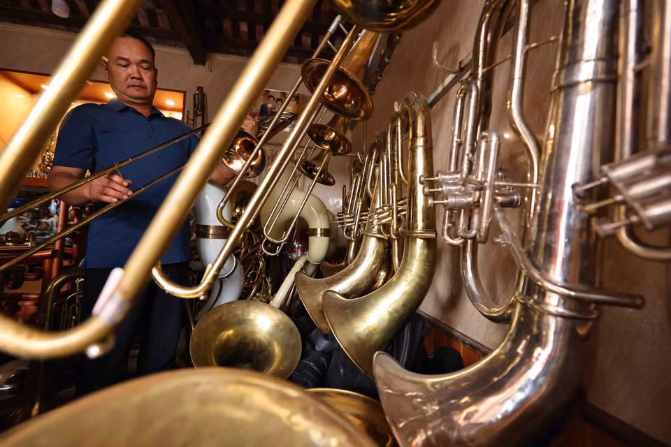 Nguyen Van Huong, a local resident, checks a brass instrument. (Photo: Minh Duc)