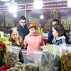 Local residents and visitors tour and shop at a fair. (Photo: VNA)