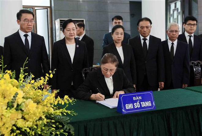 Lao Vice President Pany Yathotou writes in the condolence book for former State President Tran Duc Luong. (Photo: VNA) lao.jpg