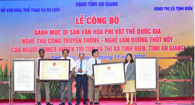 Deputy Director of the An Giang Department of Culture, Sports, and Tourism Truong Ba Trang (third from left) presents the decision from the Minister of Culture, Sports, and Tourism recognising the palm sugar-making craft of the Khmer ethnic minority in Tri Ton district and Tinh Bien township, An Giang province, as part of the national intangible cultural heritage. (Photo: VNA) an-giang3.png