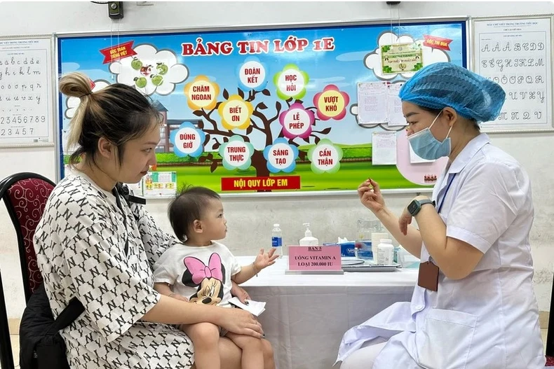A child receives a free high-dose vitamin A pill. (Photo: VNA)