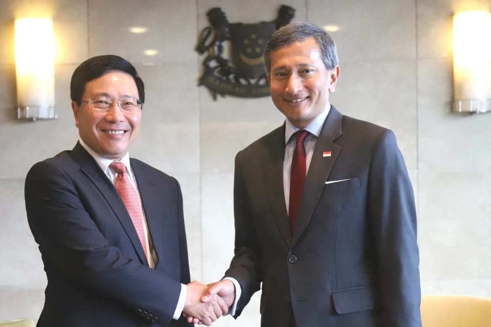 Deputy Prime Minister and Foreign Minister Pham Binh Minh (L) is welcomed by Singaporean Foreign Minister Vivian Balakrishnan on July 31 (Photo: VNA)