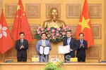 Deputy Prime Minister Tran Luu Quang (R) and Chief Executive of the Hong Kong Special Administrative Region (China) Lee Ka-chiu (L) witness the exchange of the MoU between Vietnam Airlines and the Hong Kong International Airport (HKIA). (Photo: VNA)
