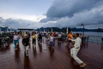 International tourists practice Tai chi aboard their cruise visiting Ha Long Bay. (Photo: VietnamPlus) 
