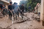 Mobile police clean up mud and houses for flood-hit people in Phuc Khanh commune, Bao Yen district, Lao Cai province. (Photo: VNA)