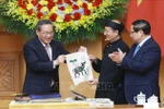 Vietnamese Prime Minister Pham Minh Chinh (R) and Chinese Premier Li Qiang got hands-on experience of making a Dong Ho folk painting. (Photo: VNA)