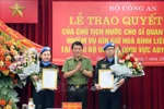 Deputy Minister of Public Security Sen. Lt. Gen. Luong Tam Quang (centre) presents the State President's decisions to the two officers on May 29. (Photo: VNA)