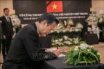 Japanese Senator Natsuo Yamaguchi writes in the condolence book. (Photo: VNA)