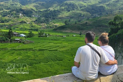 Foreign tourists enjoy the lush green rice fields in Ta Van commune, Lao Cai province. (Photo: VNA)