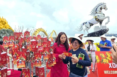 International tourists presented with New Year lucky money. (Photo: VNA)