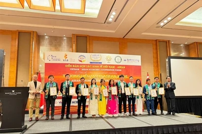 Pham Thi Bich Hanh, (seventh from right, pink dress) receives the ASEAN Strong Brands Award with other winners. (Photos courtesy of Quan An Ngon Restaurant)