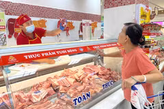 A consumer buys meat at a supermarket. (Photo: VNA)