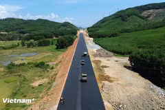 Contractors lay asphalt concrete on the roadbed of the Quy Nhon–Chi Thanh Expressway project. (Photo: VietnamPlus) 
