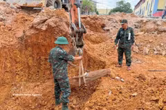 Military personnel move the bomb to a designated disposal site. (Photo: VNA)