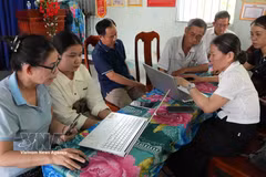 Members of the Phuong Quy 2 hamlet community digital technology team in Ngok Bay commune guides residents in submitting administrative applications online. (Photo: VNA) 