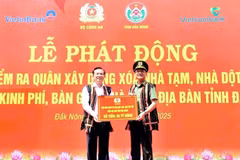 Lieutenant General Pham The Tung (R), member of the Party Central Public Security Committee and Deputy Minister of Public Security, presents the token for funding to eliminate 500 makeshift and dilapidated houses in Dak Nong province. (Photo: VNA) 