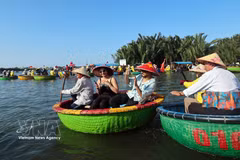 International visitors enjoy riding traditional basket boats through the coconut palm waterways of Cam Thanh village, named among the world's 50 most beautiful villages in 2025. (Photo: VNA) 